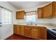 Well-lit kitchen featuring wood cabinets and a double sink near an outside door at 3216 W Paxton Ave, Tampa, FL 33611