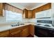 Bright kitchen with a double sink, wood cabinets, and white appliances at 3216 W Paxton Ave, Tampa, FL 33611