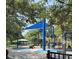 Community playground featuring slides, climbing structures, and shaded seating areas at 3216 W Paxton Ave, Tampa, FL 33611