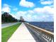 Scenic waterfront view featuring a sidewalk, lush greenery, and the tranquil waters of the bay under a partly cloudy sky at 3216 W Paxton Ave, Tampa, FL 33611