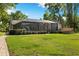 Lush backyard featuring a screened in patio and outdoor seating area perfect for entertaining at 3407 W Busch Blvd, Tampa, FL 33618