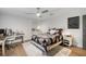 Inviting bedroom featuring bed, desk, dresser, modern ceiling fan, and light colored wood floors at 3407 W Busch Blvd, Tampa, FL 33618