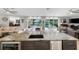 Open concept living area featuring a kitchen island with a view of the lake and pool at 3407 W Busch Blvd, Tampa, FL 33618