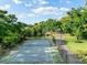 Private tennis court on a lush property with beautiful trees and scenery at 3407 W Busch Blvd, Tampa, FL 33618