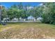 A large backyard offers plenty of green space, a white fence line, and mature tree coverage at 3527 101St E Ave, Parrish, FL 34219