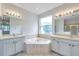 Bright bathroom with soaking tub nestled between two vanities with mirrors at 3527 101St E Ave, Parrish, FL 34219
