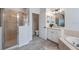 Bathroom showcasing a tiled shower, soaking tub, and vanity with abundant natural light at 3527 101St E Ave, Parrish, FL 34219