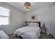 This bedroom has a queen bed, neutral-colored walls, and a unique modern light fixture at 3527 101St E Ave, Parrish, FL 34219