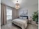 Cozy bedroom with a large window, stylish light fixture, and neutral decor at 3527 101St E Ave, Parrish, FL 34219