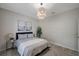 Bedroom with a large window, stylish light fixture, neutral decor, and light wood flooring at 3527 101St E Ave, Parrish, FL 34219