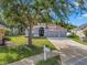 Charming home exterior with well-manicured lawn, mature landscaping, and a three car garage at 3527 101St E Ave, Parrish, FL 34219