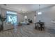 Bright, open living space with hardwood floors, modern sofas, and sliding glass doors to the backyard at 3527 101St E Ave, Parrish, FL 34219