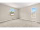 Bright, carpeted bedroom featuring two windows which illuminate the neutral walls and plush floors at 4210 N Central N Ave, Tampa, FL 33603