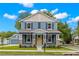 Charming two-story home with blue siding, stone accents, covered porch, and a bright yellow front door at 4210 N Central N Ave, Tampa, FL 33603