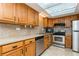 Well-equipped kitchen featuring stainless steel appliances and oak cabinets, complemented by granite countertops at 450 Treasure Island Cswy # 505, Treasure Island, FL 33706