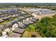 An aerial view shows the neighborhood homes, a pond and school at 4528 Ballantrae Blvd, Land O Lakes, FL 34638