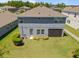 A neatly landscaped backyard with healthy lawn, screened-in patio and a view of the two-story home at 4528 Ballantrae Blvd, Land O Lakes, FL 34638
