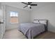 Bright bedroom with ceiling fan, large window, and bed with gray and white patterned coverlet at 4528 Ballantrae Blvd, Land O Lakes, FL 34638
