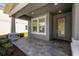 Charming front porch with stone accents, neutral gray paint, and a patterned brick walkway leading to the front door at 4528 Ballantrae Blvd, Land O Lakes, FL 34638