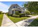 Well-maintained lawn with manicured bushes and a young palm tree enhance the curb appeal of this gray two-story home at 4528 Ballantrae Blvd, Land O Lakes, FL 34638