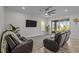 Bright living room with leather couches, ceiling fan, wood floors, and sliding doors to the patio at 4528 Ballantrae Blvd, Land O Lakes, FL 34638