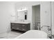 Bright bathroom with a gray vanity, modern fixtures, and an adjacent toilet room, offering a clean and functional design at 5009 W Longfellow Ave, Tampa, FL 33629