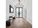 Elegant foyer with hardwood floors, a modern light fixture, and stylish double doors at 5009 W Longfellow Ave, Tampa, FL 33629