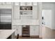 The kitchen features custom white cabinets, a wine refrigerator, and stainless steel appliances at 5009 W Longfellow Ave, Tampa, FL 33629
