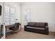 Bright home office featuring a comfortable sofa, desk, and elegant window shutters at 5009 W Longfellow Ave, Tampa, FL 33629