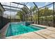 Stunning screened-in pool with an attached hot tub, surrounded by lush greenery and bathed in sunlight, perfect for relaxation at 5009 W Longfellow Ave, Tampa, FL 33629