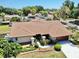 An aerial view of a well-maintained home featuring manicured landscaping, driveway, and a lush lawn at 501 Sportsman Park Dr, Seffner, FL 33584