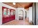 Inviting foyer featuring a unique red double door with stained glass, light tile flooring, and an arch window at 501 Sportsman Park Dr, Seffner, FL 33584