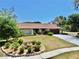 Inviting home with manicured lawn, decorative flower beds, and a concrete driveway at 501 Sportsman Park Dr, Seffner, FL 33584