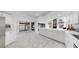 Spacious kitchen with marble floors, white cabinets, island, and adjacent living spaces at 501 Sportsman Park Dr, Seffner, FL 33584