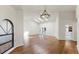 Open living room with wood flooring, skylights, chandelier, arched window, and a door to the kitchen at 501 Sportsman Park Dr, Seffner, FL 33584