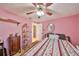 A cozy bedroom features pink walls, a ceiling fan, and comfortable furnishings at 601 Cedar Grove Dr, Brandon, FL 33511