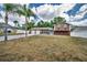 Two-story home with a two-car garage, highlighted by palm trees, set against a backdrop of blue skies and clouds at 613 Valley Hill Dr, Brandon, FL 33510