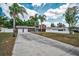 Two story house with a two car garage surrounded by palm trees under a blue cloudy sky with a large driveway at 613 Valley Hill Dr, Brandon, FL 33510