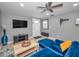 Living room with a blue sofa, TV, modern fan, and hardwood floors at 613 Valley Hill Dr, Brandon, FL 33510