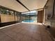 Covered and screened patio area with brown tile flooring leads to the backyard pool at 613 Valley Hill Dr, Brandon, FL 33510