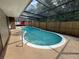 An in-ground pool sits in the screened in lanai with a fence in the background at 613 Valley Hill Dr, Brandon, FL 33510