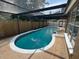 The screen-enclosed pool has a fence nearby, surrounded by mature trees at 613 Valley Hill Dr, Brandon, FL 33510