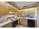 Functional kitchen with wood cabinets, essential appliances, and a pass-through to the living area at 6357 Bahia Del Mar Blvd # 111, St Petersburg, FL 33715