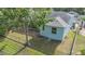 Backyard of a light blue home featuring a chain-link fence and green grassy area at 7039 Woodibis Dr, New Port Richey, FL 34654