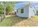 Sideyard of light blue home featuring a chain-link fence and green grassy area at 7039 Woodibis Dr, New Port Richey, FL 34654
