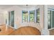 Bright breakfast nook with wood-look floors, large windows, and sliding door access to the lanai at 7039 Woodibis Dr, New Port Richey, FL 34654