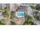 Aerial view of a community pool surrounded by trees, walkways, and parking at 7039 Woodibis Dr, New Port Richey, FL 34654