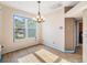Sunlit dining area with wood-look floors, a modern chandelier, and a large window with neighborhood views at 7039 Woodibis Dr, New Port Richey, FL 34654