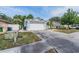 Residential street view of a single-story home with a two-car garage, and a landscaped front yard at 7039 Woodibis Dr, New Port Richey, FL 34654