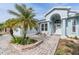 Inviting home entrance with a brick walkway, front yard landscaping, and an arched doorway framed by pillars at 7039 Woodibis Dr, New Port Richey, FL 34654